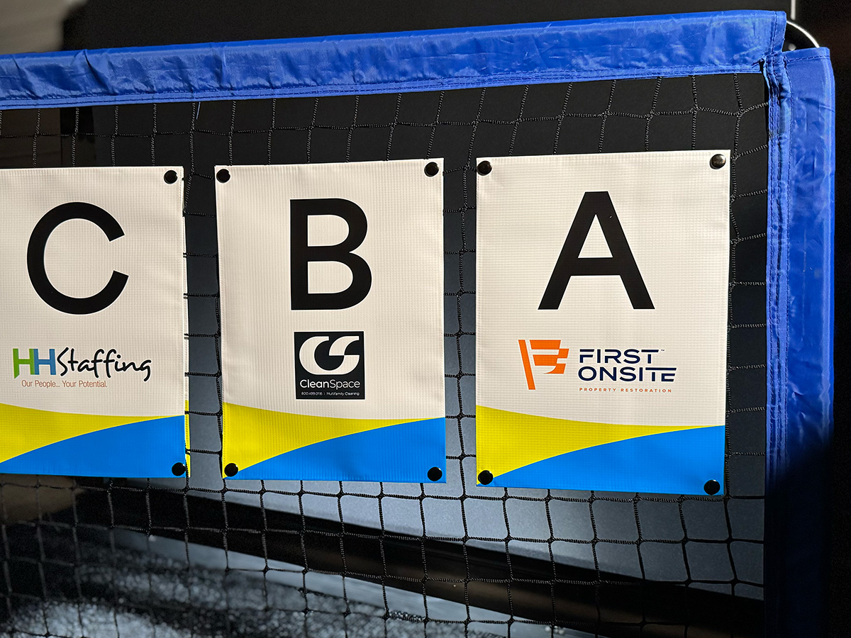 Multi-sponsor volleyball net banner setup with HH Staffing, CleanSpace, and First Onsite banners