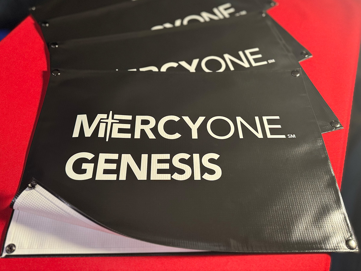 Stack of custom printed MercyOne Genesis snap-on net banners